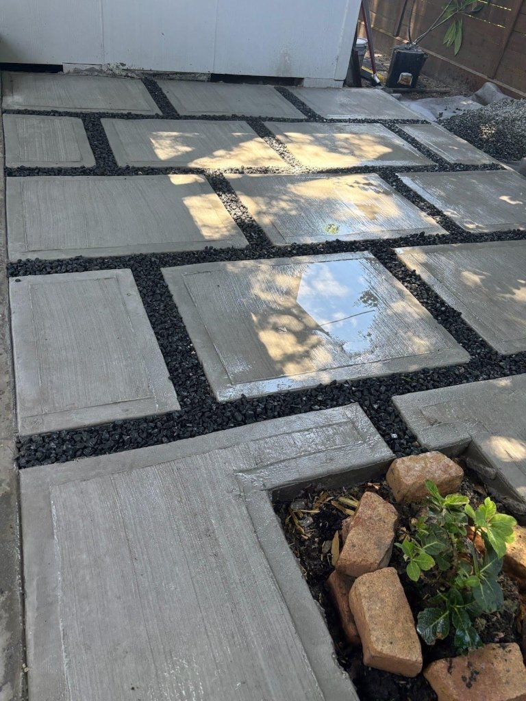 Modern concrete steppers and black gravel patio installation by Quintana Stone
